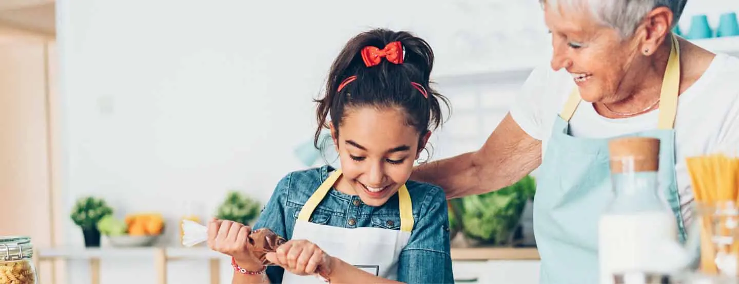 Grandmother baking with granddaughter after reviewing a home-buying guide