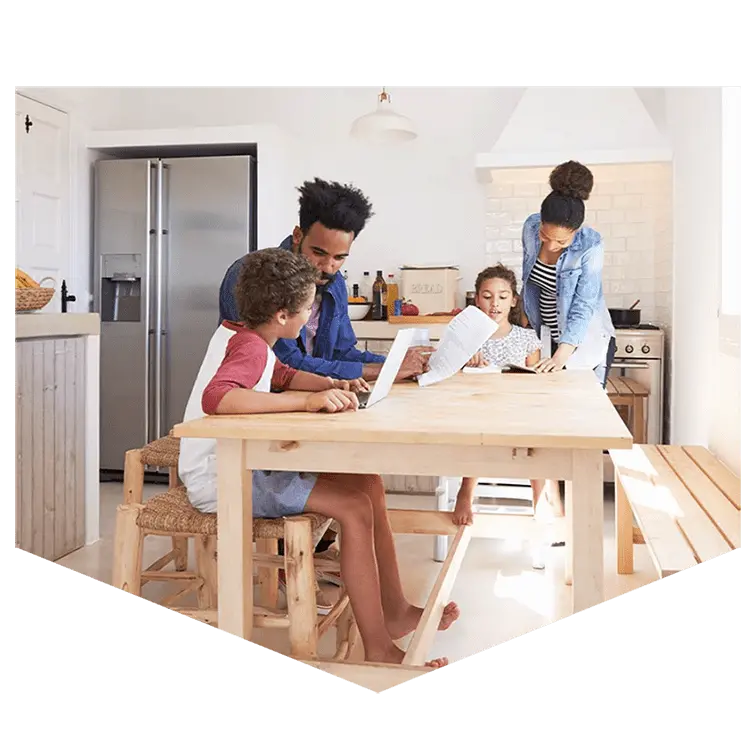 A family around a kitchen table discussing affordable mortgage options together. 