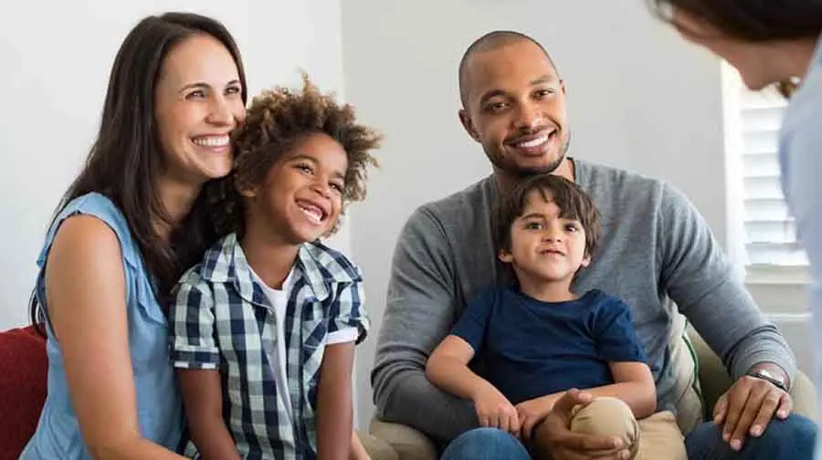 Family sitting on couch smiling