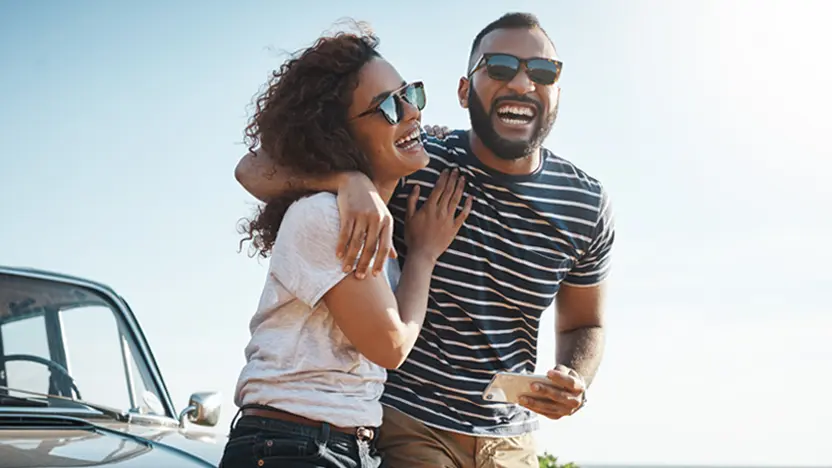 Man and woman with arms around each other, smiling 
