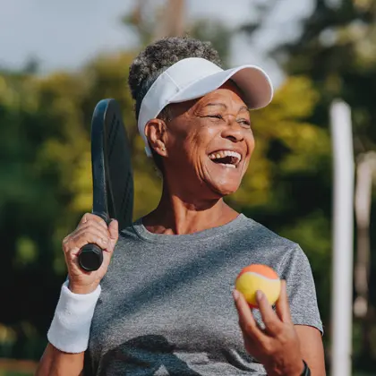 Woman holding pickle ball racket and smiling