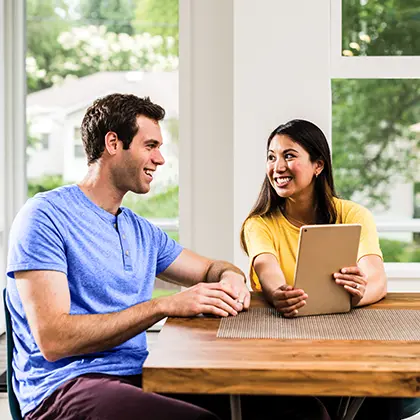 Couple sitting at table smiling at each other 