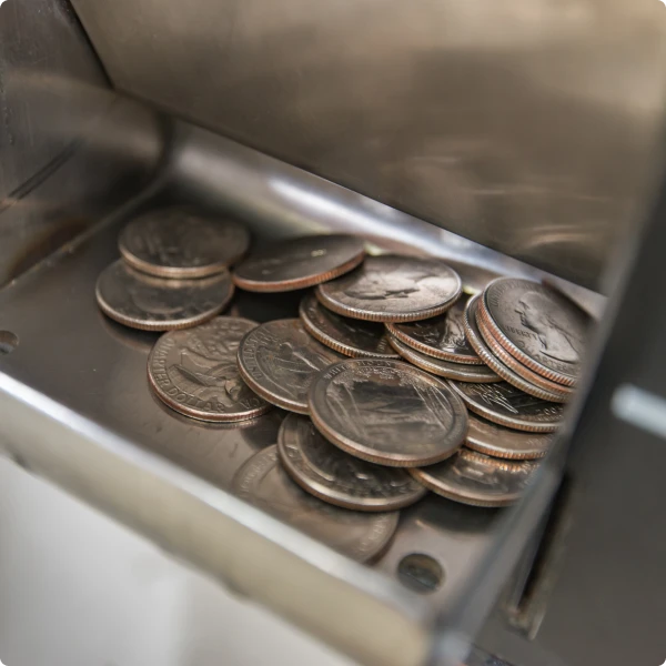 A group of quarters in a coin slot of a coin counting kiosk