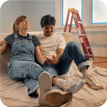 Couple laughing while making home improvements.