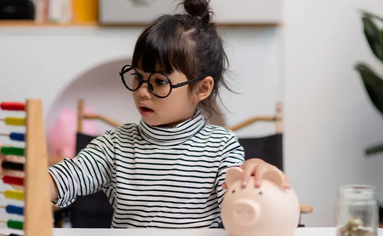 Young child counting using an abacus at a desk