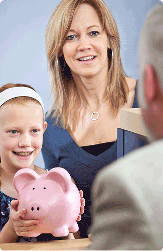 Mom with daughter holding piggy bank.