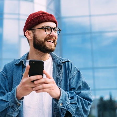 Person standing outside in the city holding smartphone