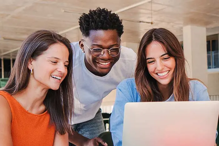 Group of students looking at a laptop