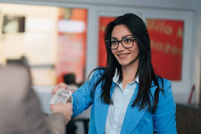 Persona mostrando su Tarjeta Matricular a un representante bancario