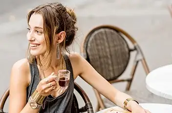 Affluent traveler sitting outside enjoying coffee while on vacation