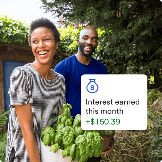 Two people outdoors, one holding a pot of plants. A graphic overlay shows ‘Interest earned this month +$150.39’ with a money bag icon.