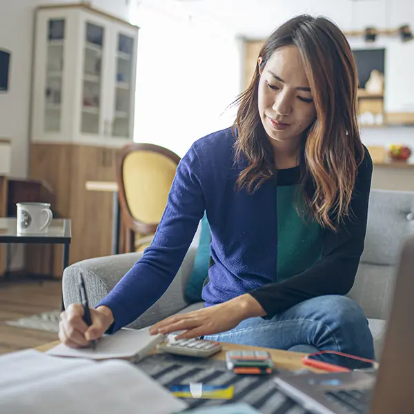 Woman writing on a notepad in her living room