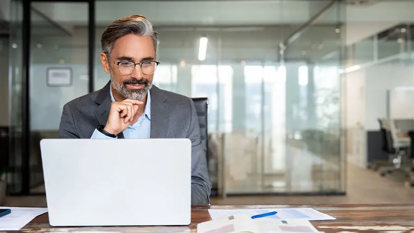 business man working at laptop considering donating stock to charity