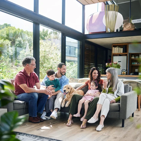 6 members of a multi-generational family and their dog talking in their living room