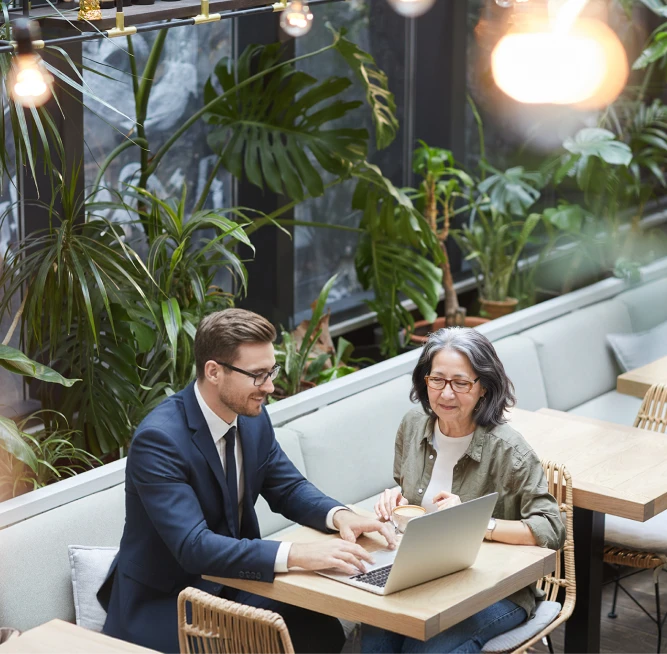 Older woman meeting with a financial advisor at a coffee shop