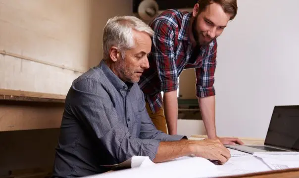 Two business men discussing portfolios over a desk