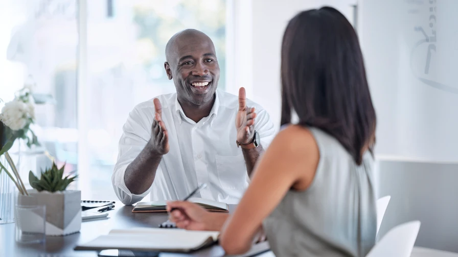 Businessman sitting on a leather couch talking with his financial planner