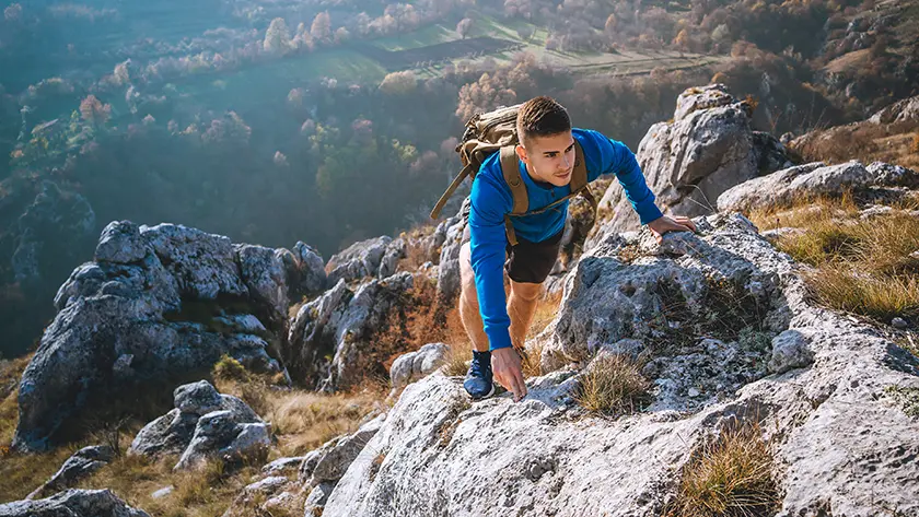 person standing on a mountain looking at the horizon