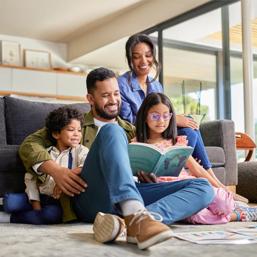 father reading story to children at home