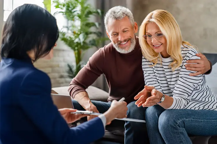 Couple discussing wealth with an advisor at an office