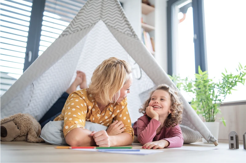 Mom and daughter playing in a fort in their living room