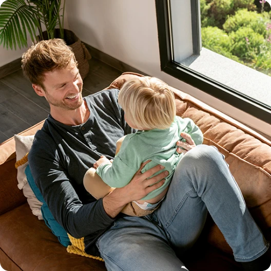 Young dad holding his son on his lap 