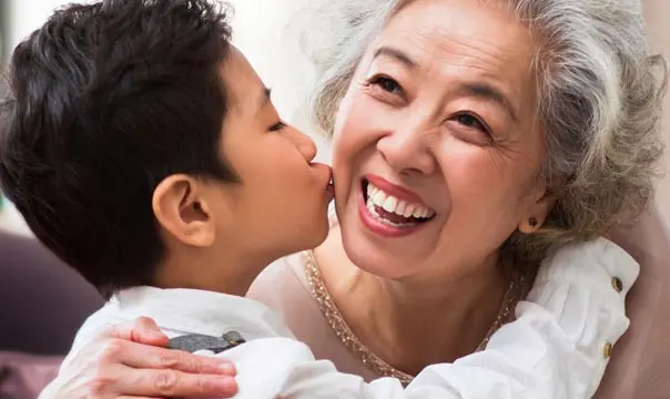 Grandson kissing grandmother on cheek