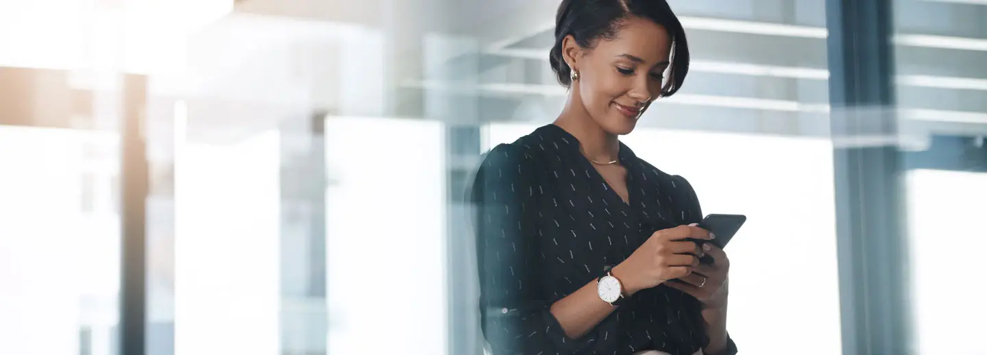 woman looking down and smiling at her phone
