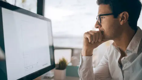man looking at computer screen monitor