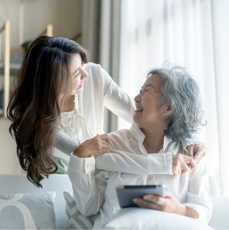 Older woman smiling and talking with her middle-aged daughter