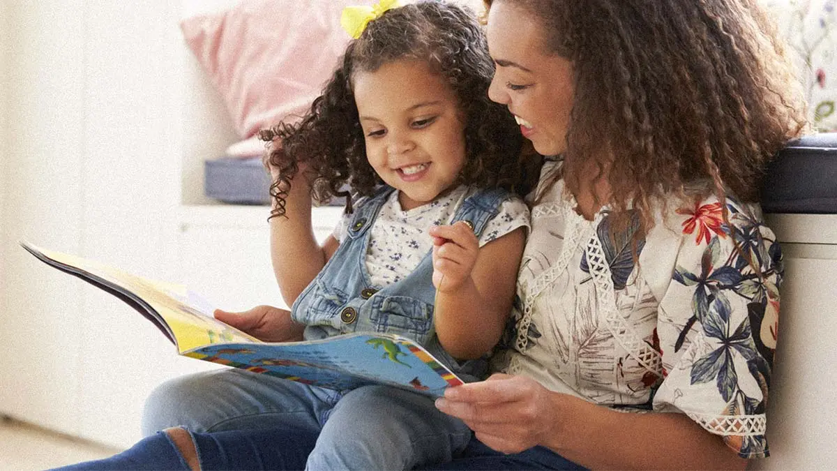 Mother reading book to daughter