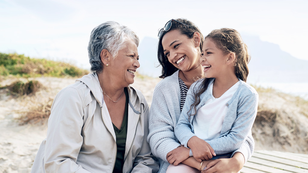 three generations of women smiling outdoors