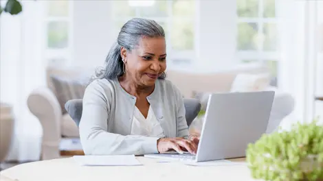 older woman reviews finances on laptop
