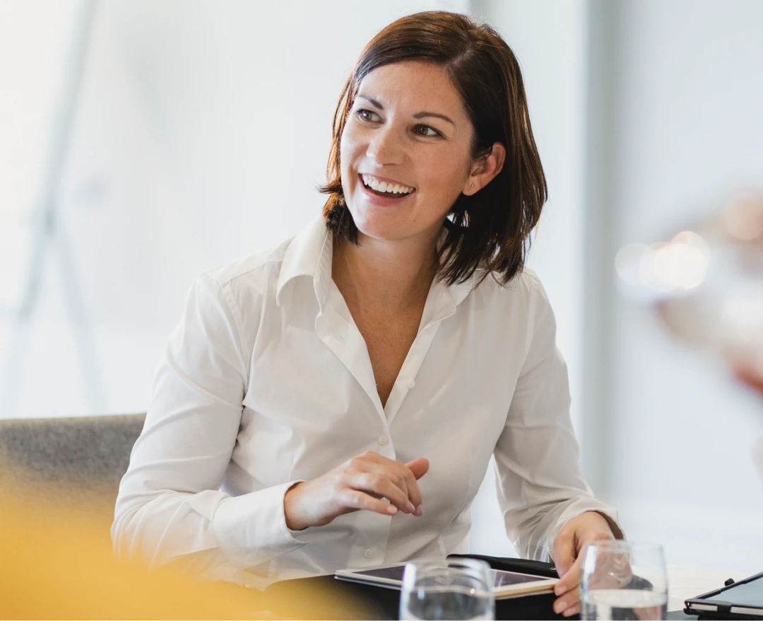 Business executive sitting at a table smiling as she plans her finnaces