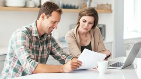 couple sitting in their kitchen reviewing paperwork