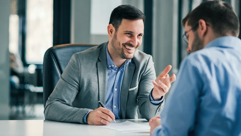 Younger man in his financial advisor's office discussing IRA options  