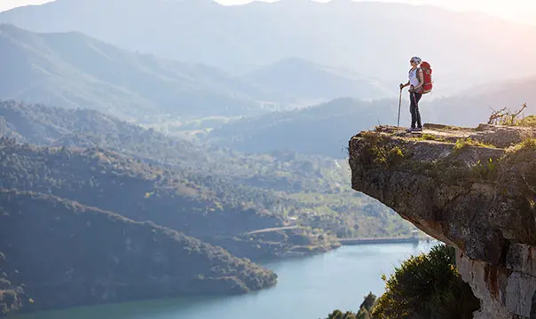 person standing on a mountain looking at the horizon