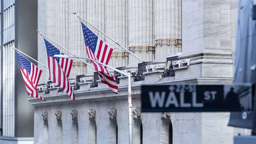 close up of U.S. flags flying on building on Wall Street