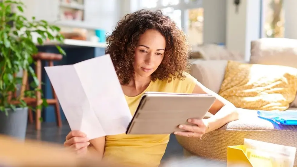 woman sitting on the floor reviewing trust terms on her iPad