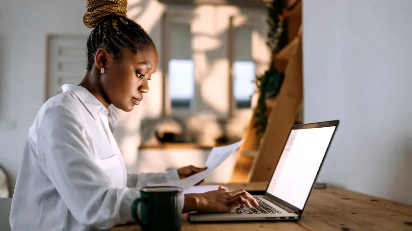 woman working at desk on computer managing self-employment income