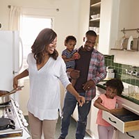 African American Family At Home Preparing Meal In Kitchen Together
