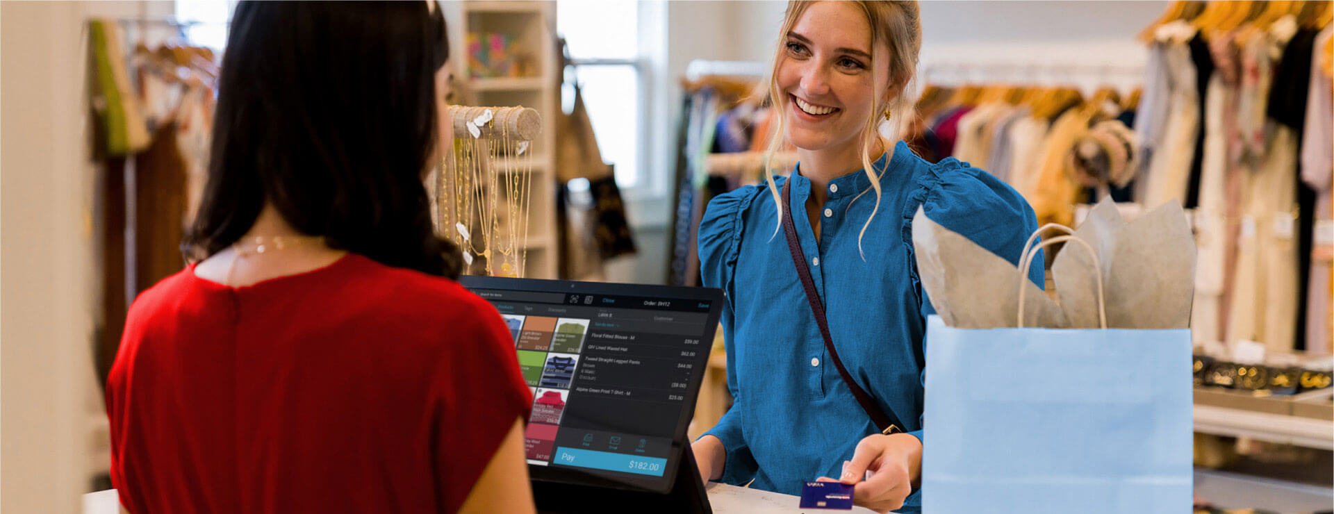 Woman at point-of-sale in clothing store at check out with credit card