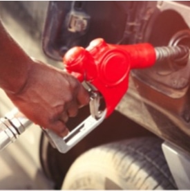 Person holding fuel pump nozzle inserted into fleet vehicle