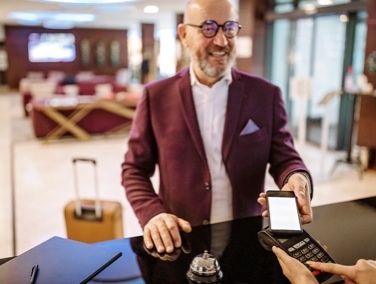 Person holding mobile device to a point of sale reader using virtual payments