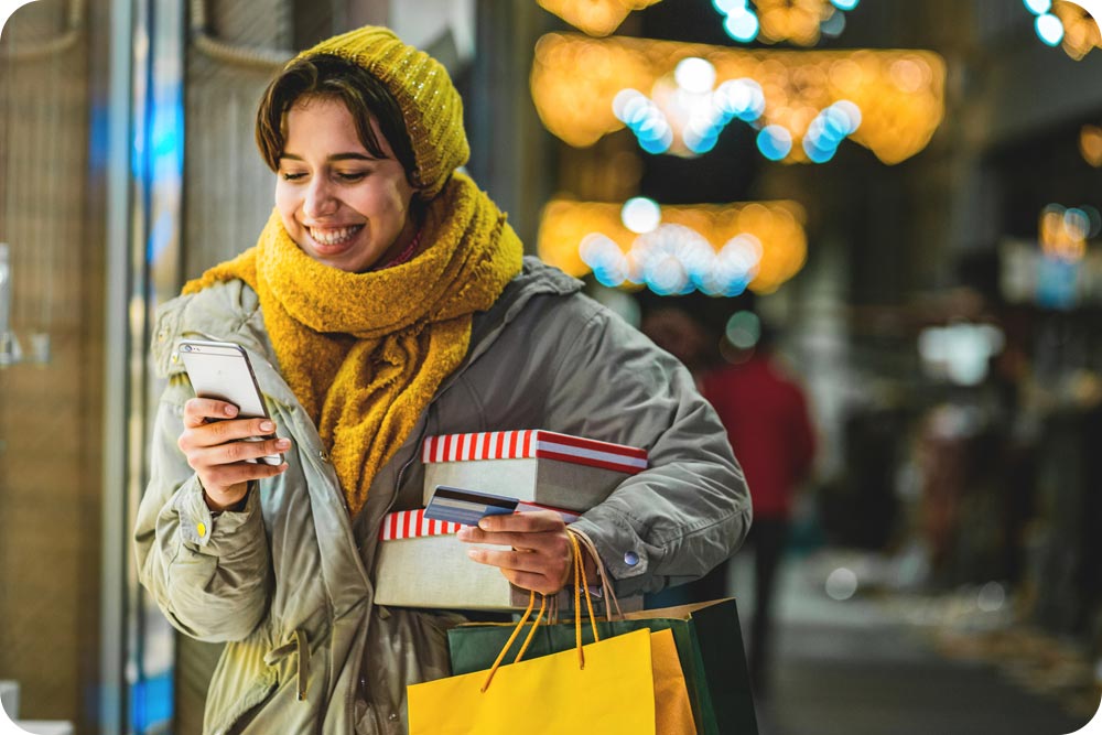 Woman in winter clothing shopping with a holiday backdrop