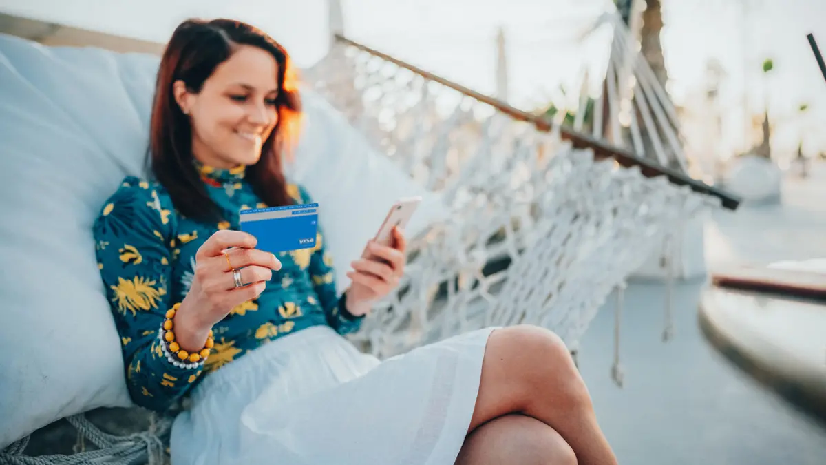 Woman holding credit card and phone. 