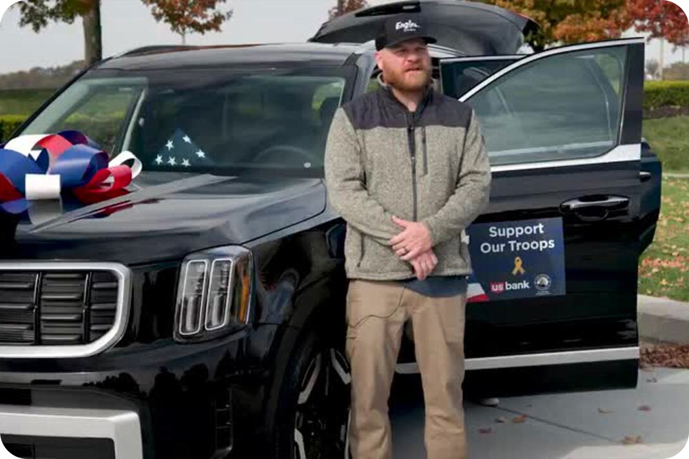 Photo of a man standing in front of a car