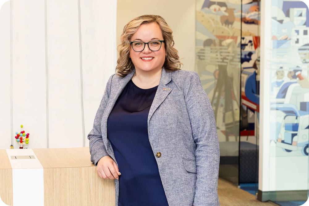 A woman standing and smiling at the camera.