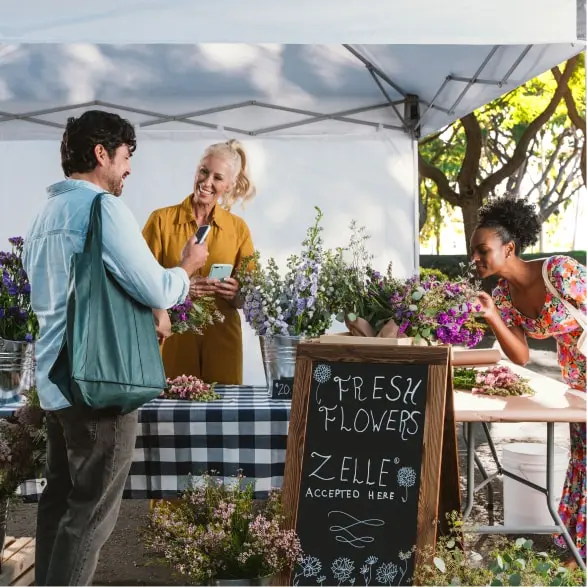 Customer making a purchase using a smartphone with US Bank App at Fresh Flowers where Zelle is accepted.