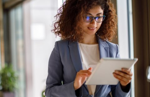 Woman wearing a blazer using a tablet device